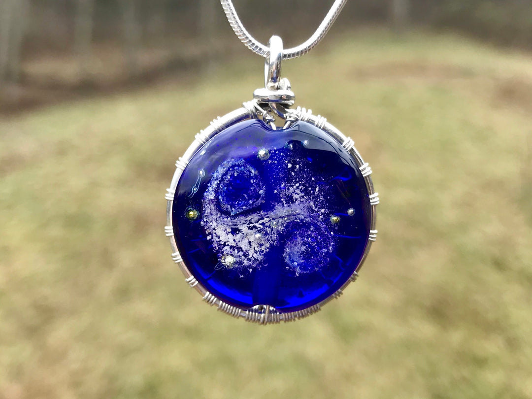 Cobalt Starry Galaxy Tree of Life pendant featuring a silver tree and blue glass bead with cremains visible on the back.