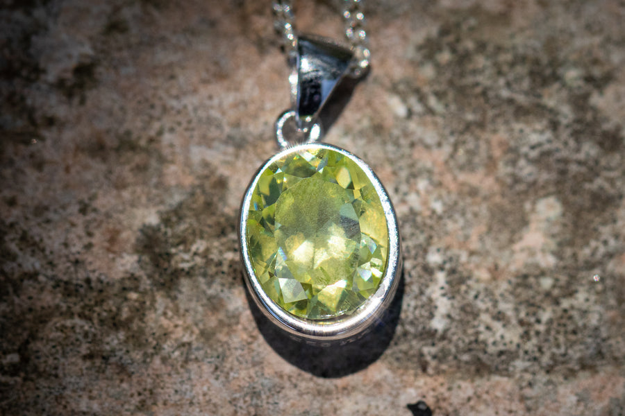 Lime green oval crystal memorial pendant in a silver bezel on a chain