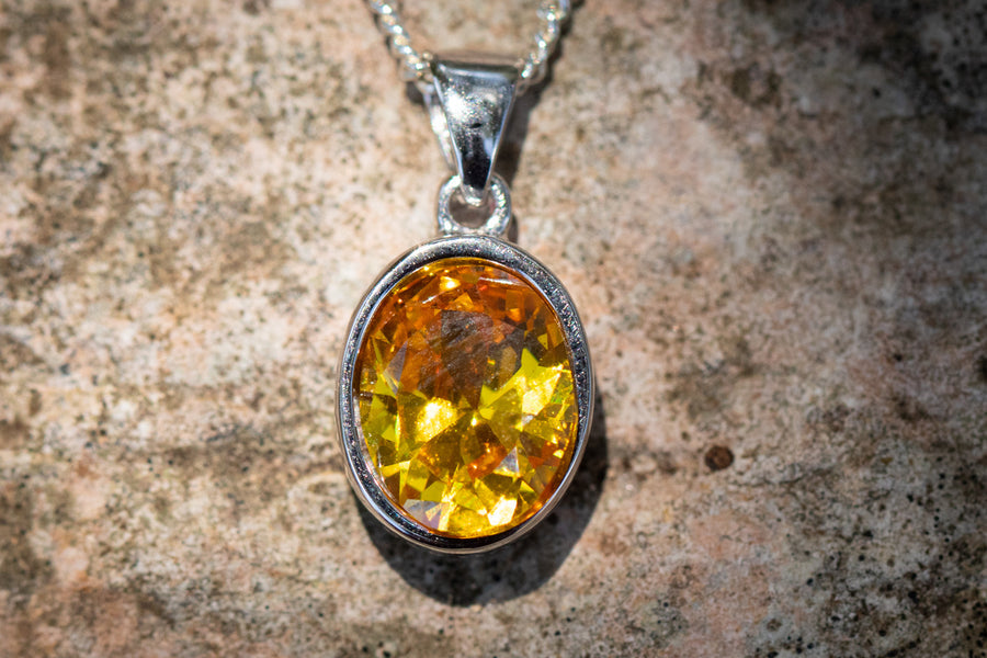 Amber oval crystal memorial pendant in silver bezel on a chain