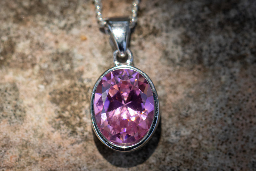 Purple pink oval crystal memorial pendant in a silver bezel on a chain
