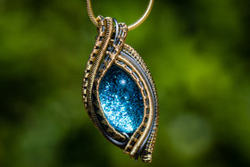 gold and silver pendant with cremation ash in blue