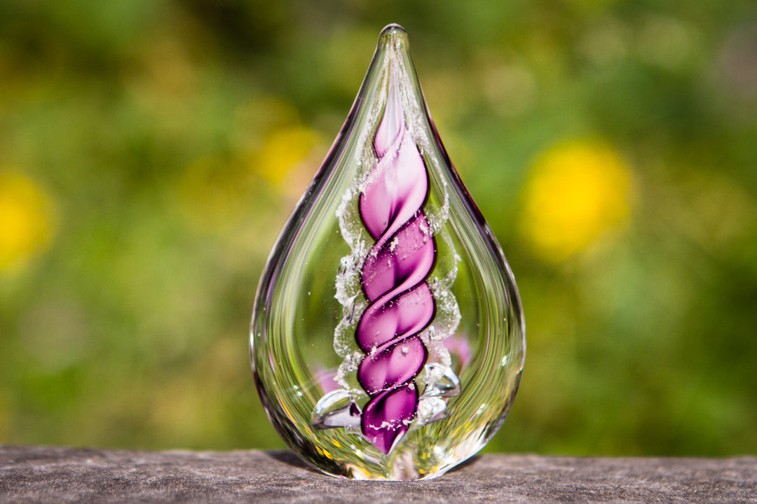 Petite memorial glass flame infused with cremation ashes, purple spiral design inside clear glass.