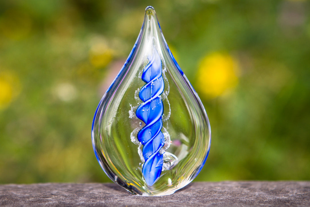 Petite memorial glass flame infused with cremation ashes, blue spiral design inside clear glass.