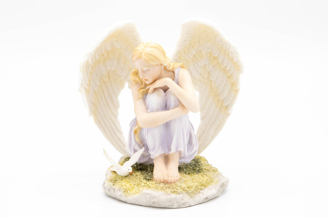 Sitting angel urn topper with lavender dress white wings and a dove on a grassy base
