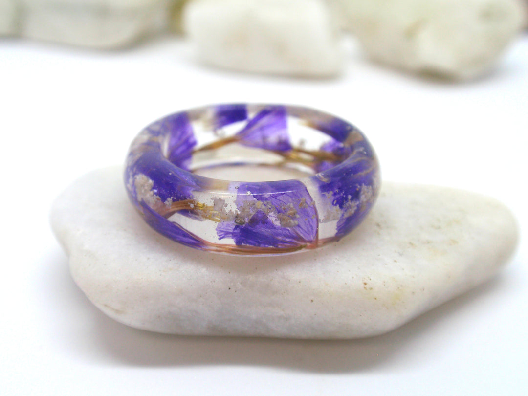 Angled view of purple flower cremation ash ring in clear resin