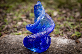 spiral glass with cremation ash in blue outdoors.