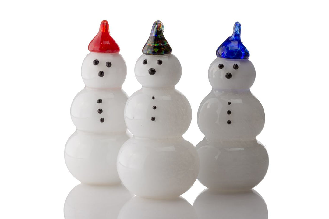 Three white friendly memorial snowmen with cremation ash and colored hats red, iridescent, and blue arranged in a row.