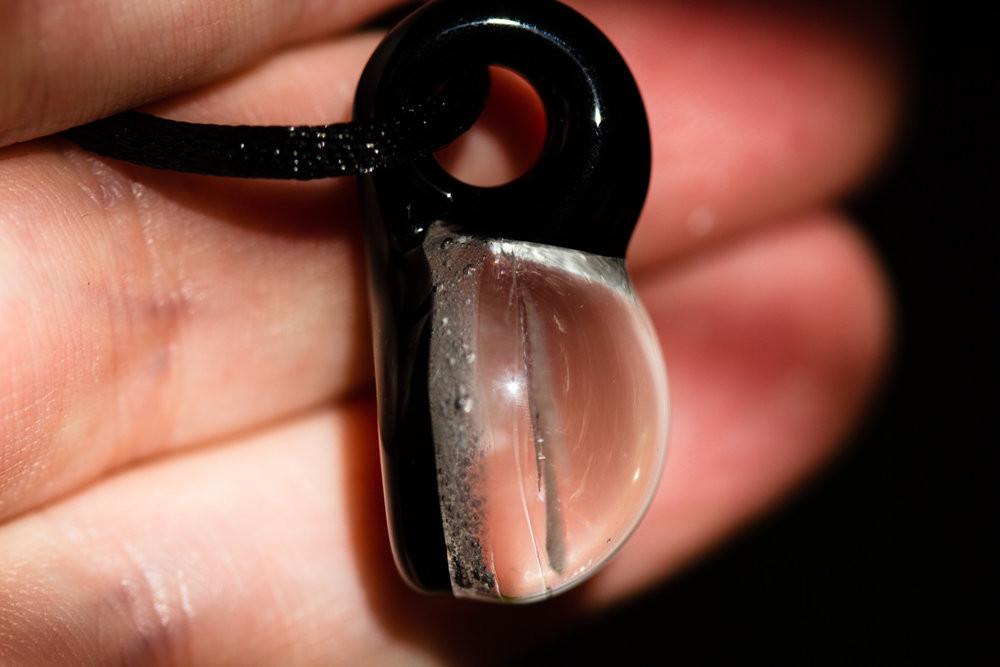 Stallion hologram glass pendant infused with cremation ash hanging from a black cord