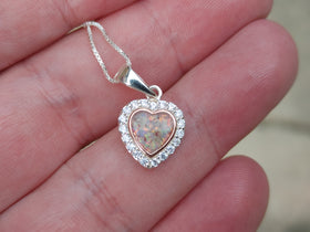bedazzled rose gold pendant with  cremation ash in hand