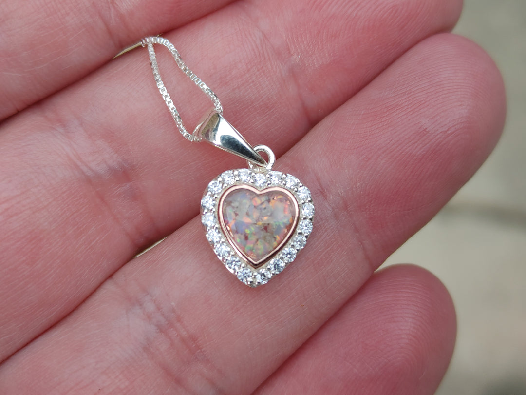 bedazzled rose gold pendant with  cremation ash in hand