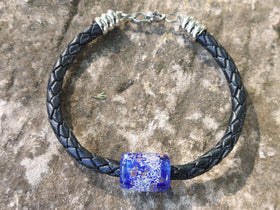 barrel bracelet with cremation ash from pets and people, sitting on stone