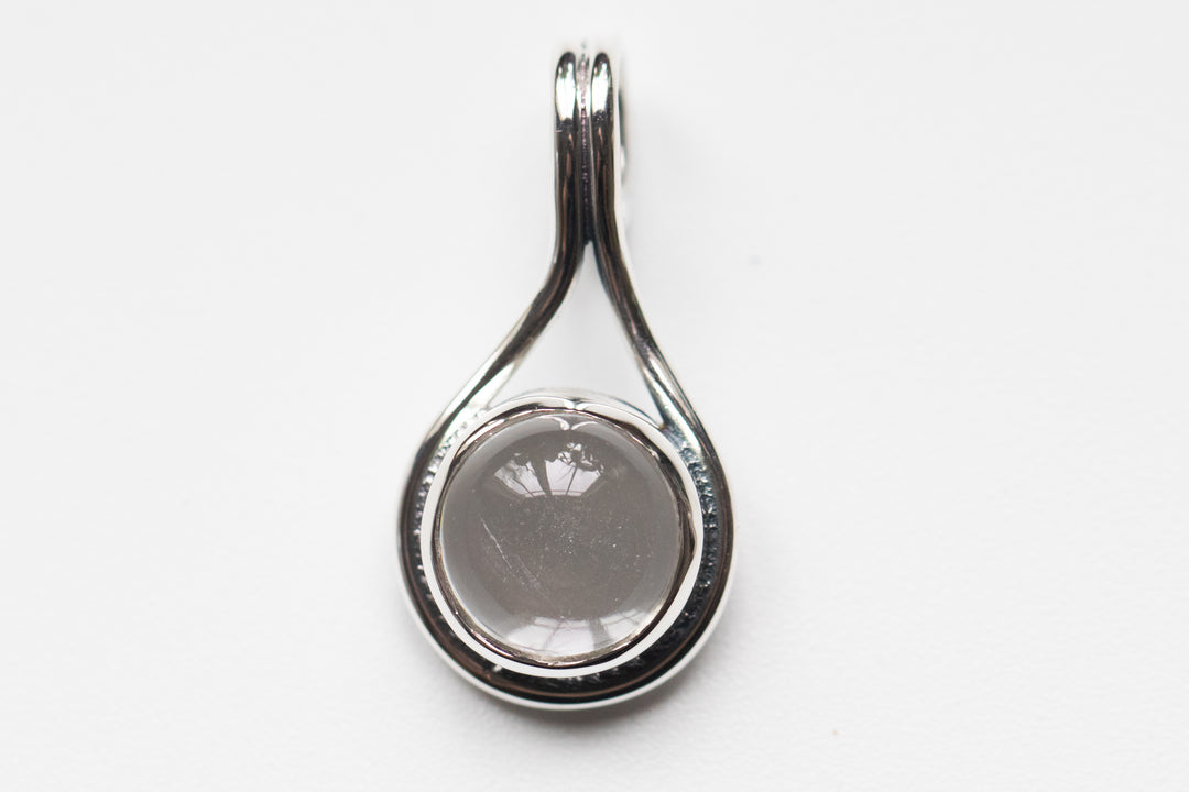 Grey circular stone in a silver teardrop memorial pendant designed to hold cremation ash