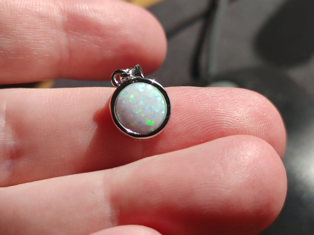 Close-up of 8mm opal cremation pendant in sterling silver showing the bezel and chain loop