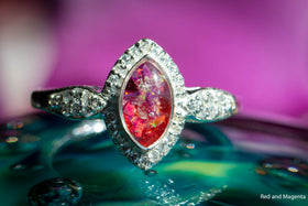 The photo is of our Bedazzled Cat Eye Cremation Ring. It is a zircon studded, sterling silver ring with a cabochon comprised of crushed opal and cremation ash. The stone in this image is red and magenta. Sterling Silver Ring, Sterling Silver Cremation Jewelry, Jewelry for Ash, Cubic Zirconia Ring, Classic Jewelry Style Ring, Ring for Cremation Ash