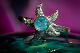 Sterling silver Bedazzled Starfish Ring, with light blue opal, sitting atop a glass surface. Sterling Silver Ring for Ash, Sterling Silver and Zircon Ring, Ring for Cremation Ash, Silver Remembrance Jewelry, Jewelry for Ash