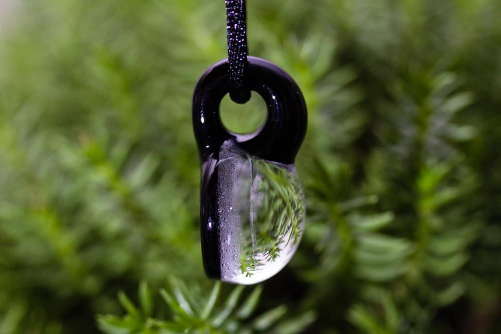 Glass hologram dragonfly pendant infused with cremation ash suspended from an adjustable cord.