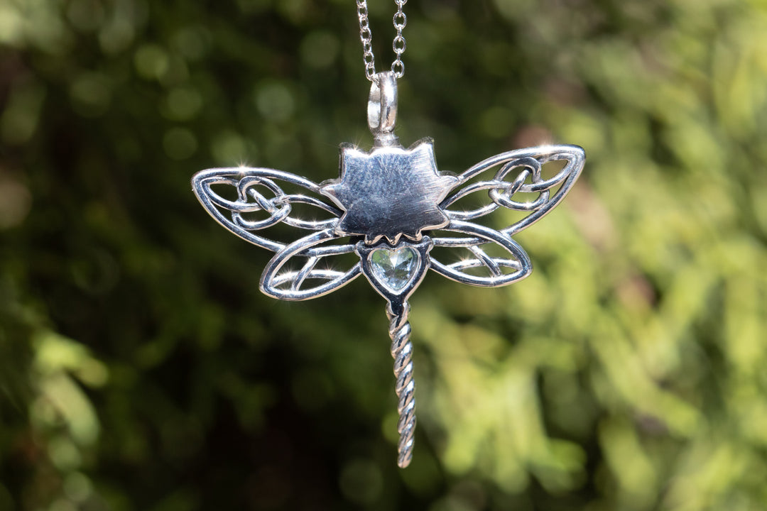 Silver dragonfly cremation necklace with a blue teardrop crystal and twisted stem pendant outdoors