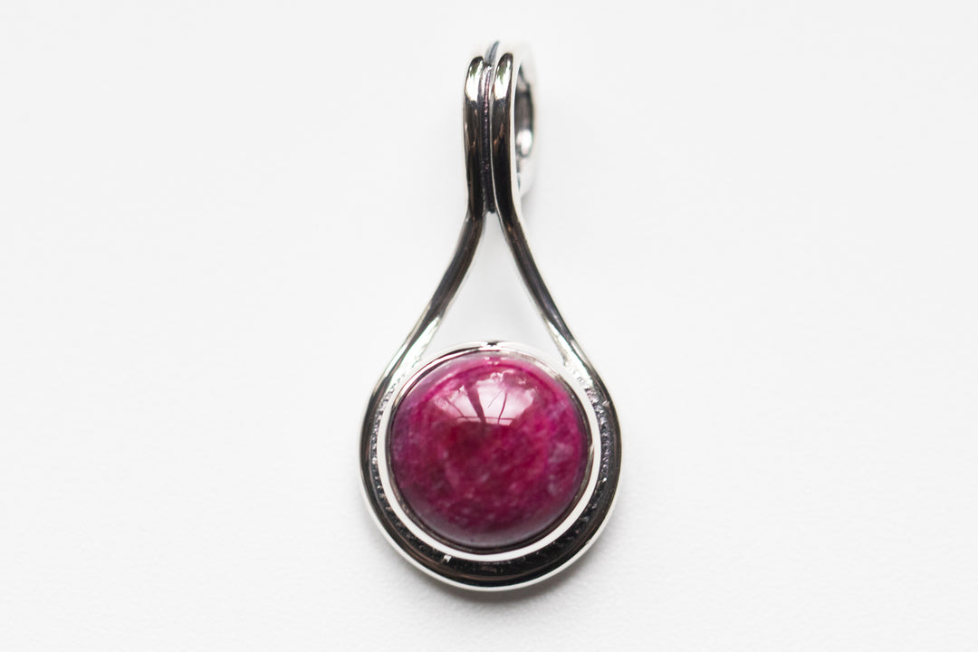 Stone Swirl Drop pendant in sterling silver with a round purple cabochon set in a curved teardrop frame