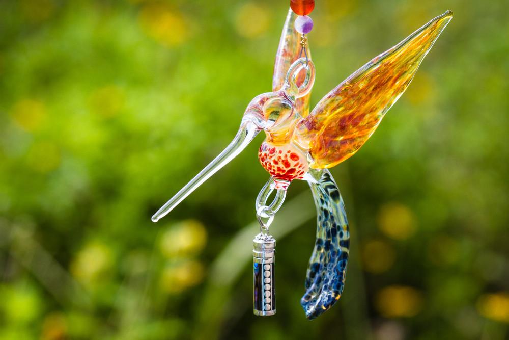 Yellow and red glass hummingbird pendant with tree and red agate beads and a silver keepsake vial under a crystal butterfly