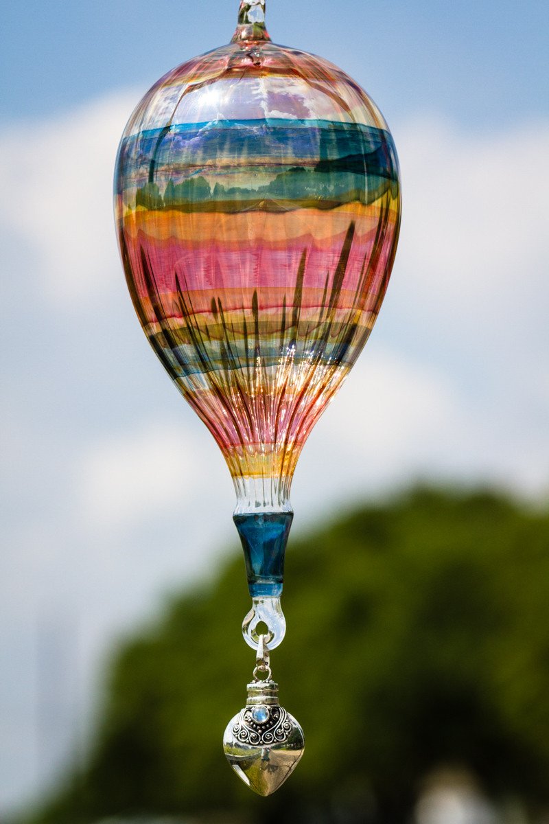 Colorful glass hot air balloon with a sterling silver keepsake urn pendant hanging below