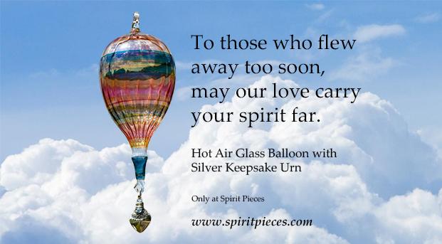 Colorful glass hot air balloon ornament against a blue sky