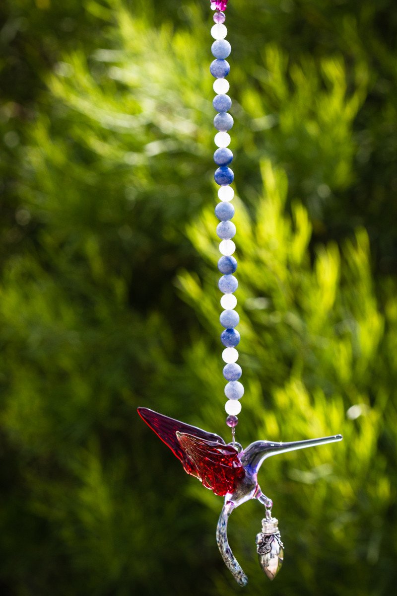 Red and light purple hummingbird glass pendant on a beaded strand with a crystal butterfly and a small keepsake urn.