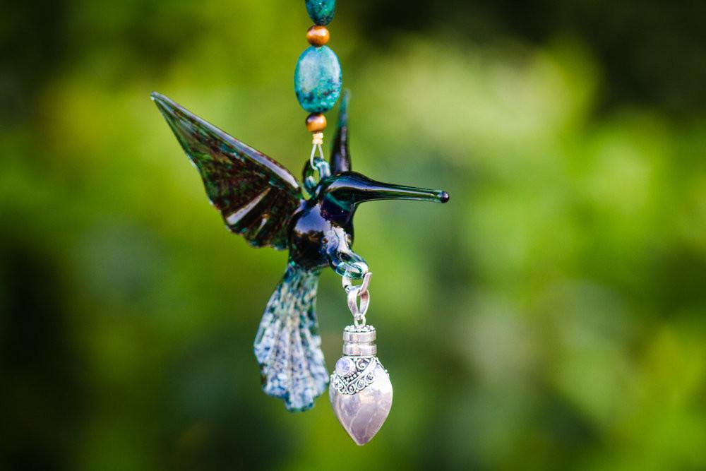Teal hummingbird glass pendant with turquoise and yellow tiger's eye beads and a crystal butterfly, attached to a silver keepsake urn.