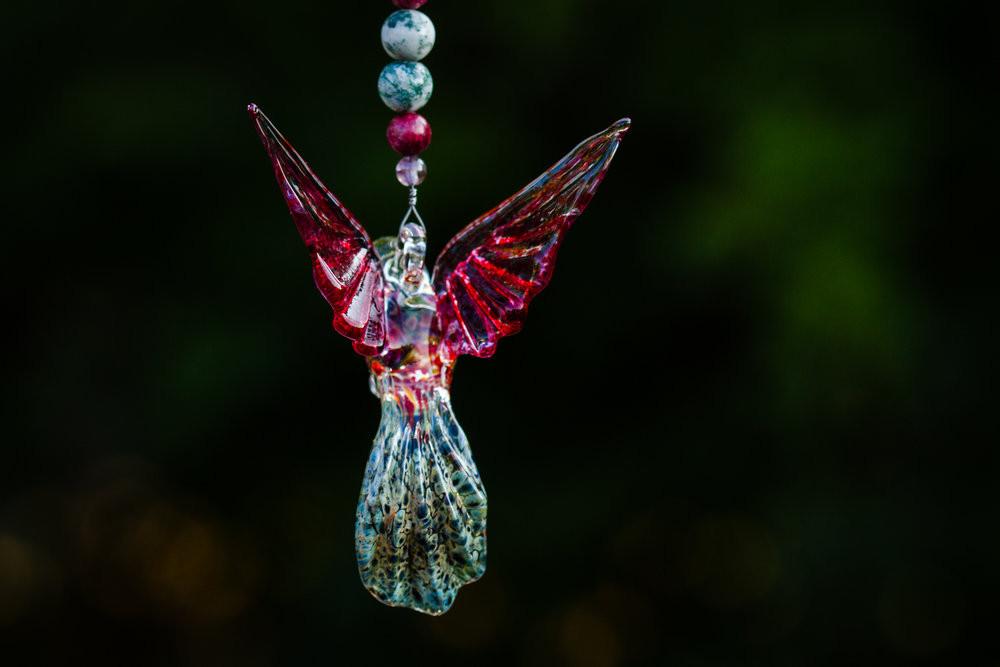 Pink and tree agate beaded necklace featuring a multicolored glass hummingbird and crystal butterfly pendant with keepsake urn.