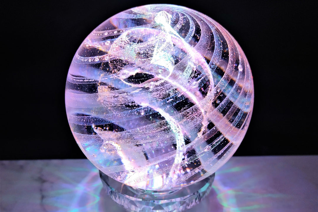dichroic glass orb with cremation ash made in memory of a loved one.