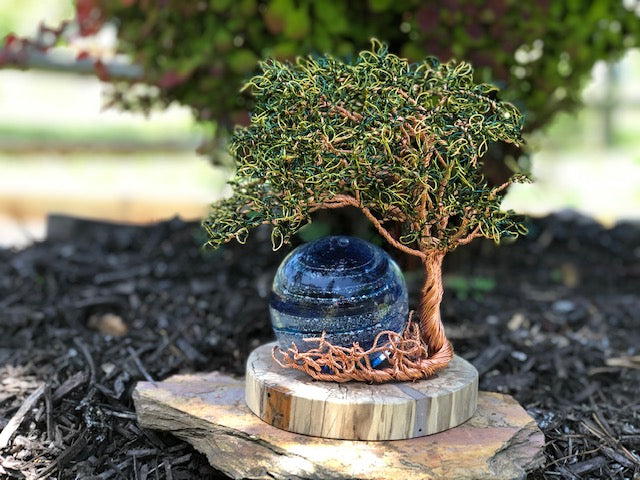 Tree of Life sculpture with a blue green glass orb centered among copper wire branches and roots on a wooden base