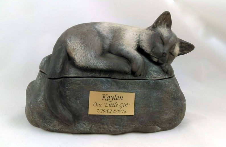 Two piece hand-painted ceramic cat urn featuring a curled sleeping cat on a stone-like base with a brass engraved plaque.