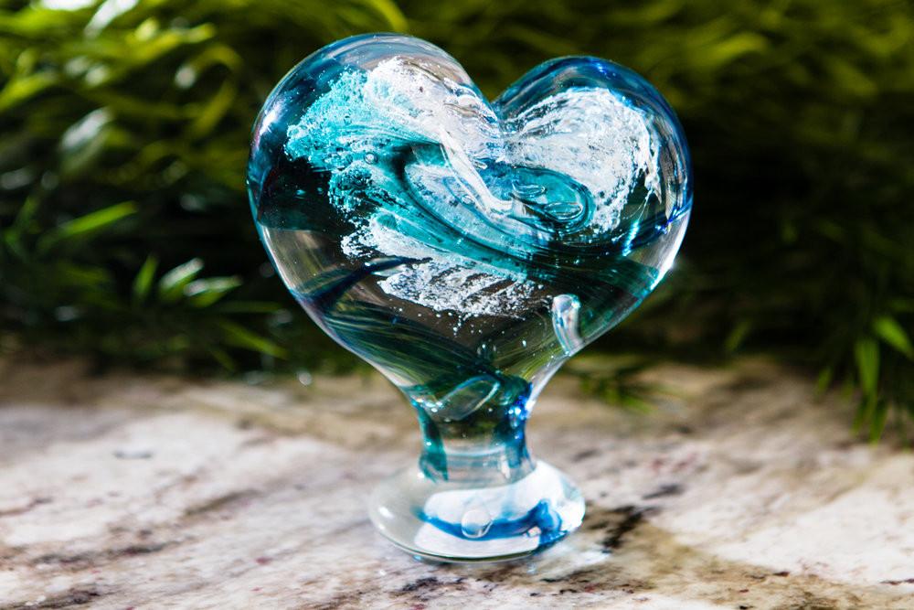 Teal and turquoise glass standing heart with swirled color patterns and cremation ash keepsake.