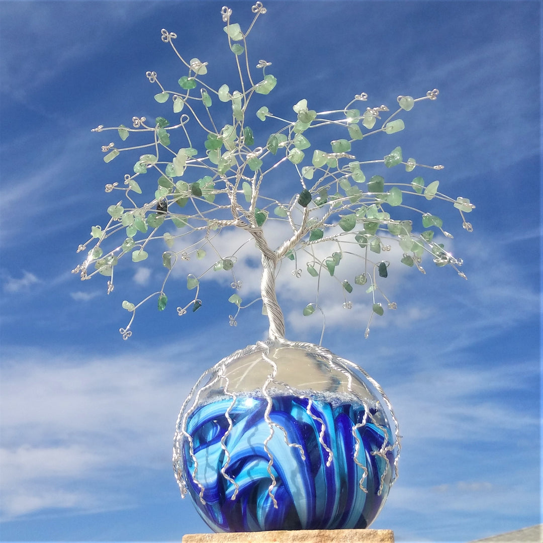 Wire wrapped tree of life with green aventurine beads atop a blue and white swirled glass orb