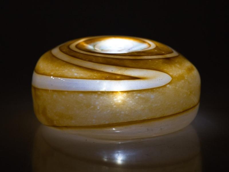 Orange tan hollow votive stone with white speckled interior and central opening for a tealight