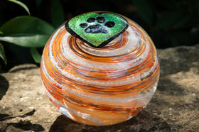glass orb with cremation ash in orange