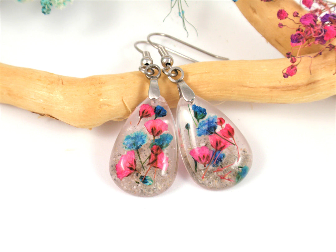 Teardrop crystal resin earrings featuring pink and blue baby's breath encased in cremains on surgical steel hooks