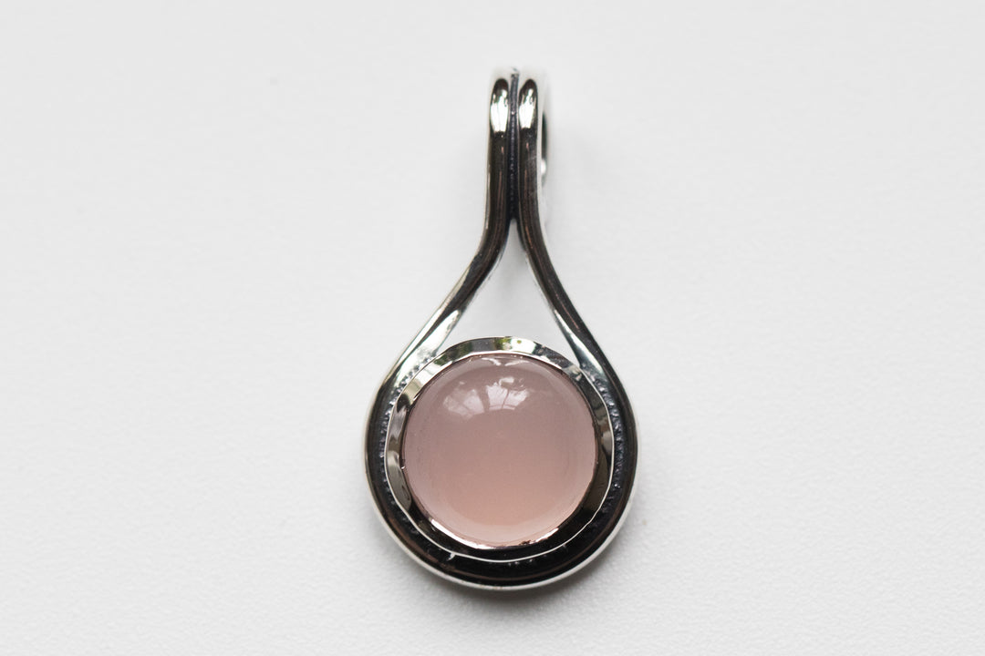Pink circular stone in a silver teardrop memorial pendant designed to hold cremation ash