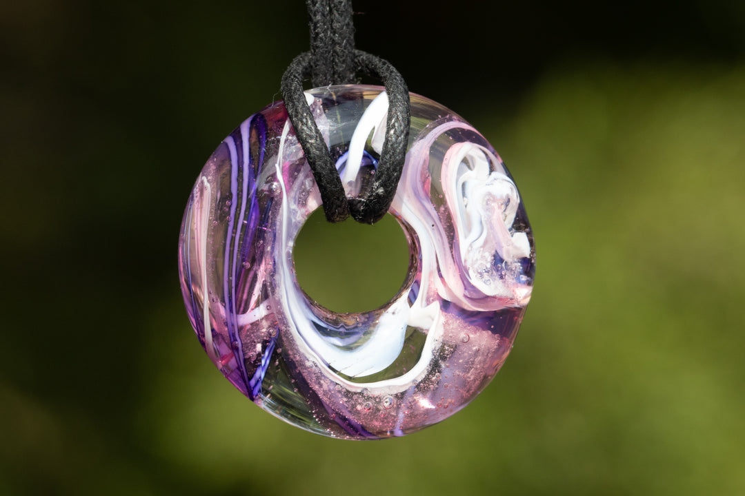 Taffy colored halo pendant with pink purple blue swirls and cremation ash on a black cord
