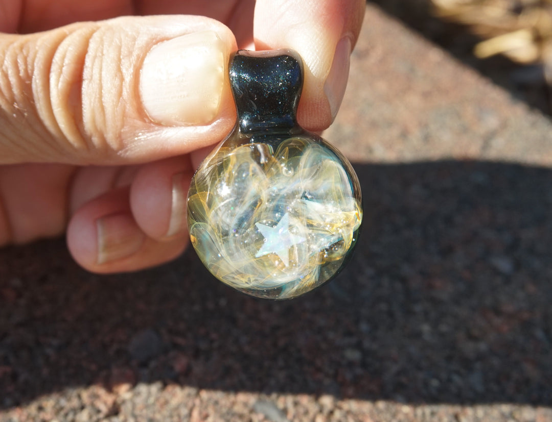Close-up of galaxy glass pendant with crescent moon in iridescent opal and cremains swirls.