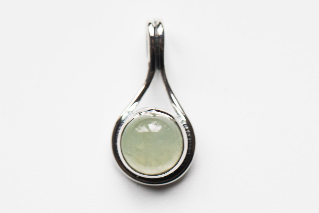 Sterling silver teardrop memorial pendant with a pale beige round stone centerpiece and back ash space