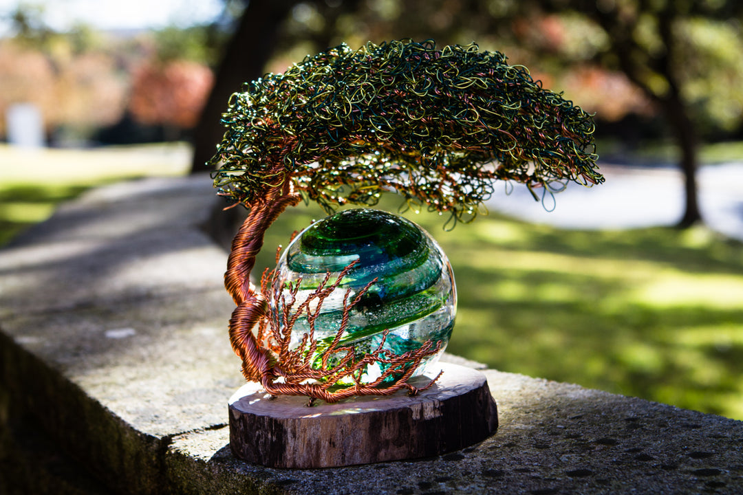 Handmade tree of life wire sculpture with copper trunk and dense green wire canopy mounted on a wooden base