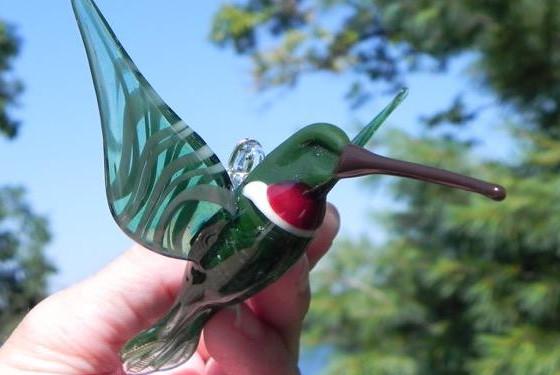Green glass hummingbird infused with cremation ashes, red throat, hanging hook on top for display.