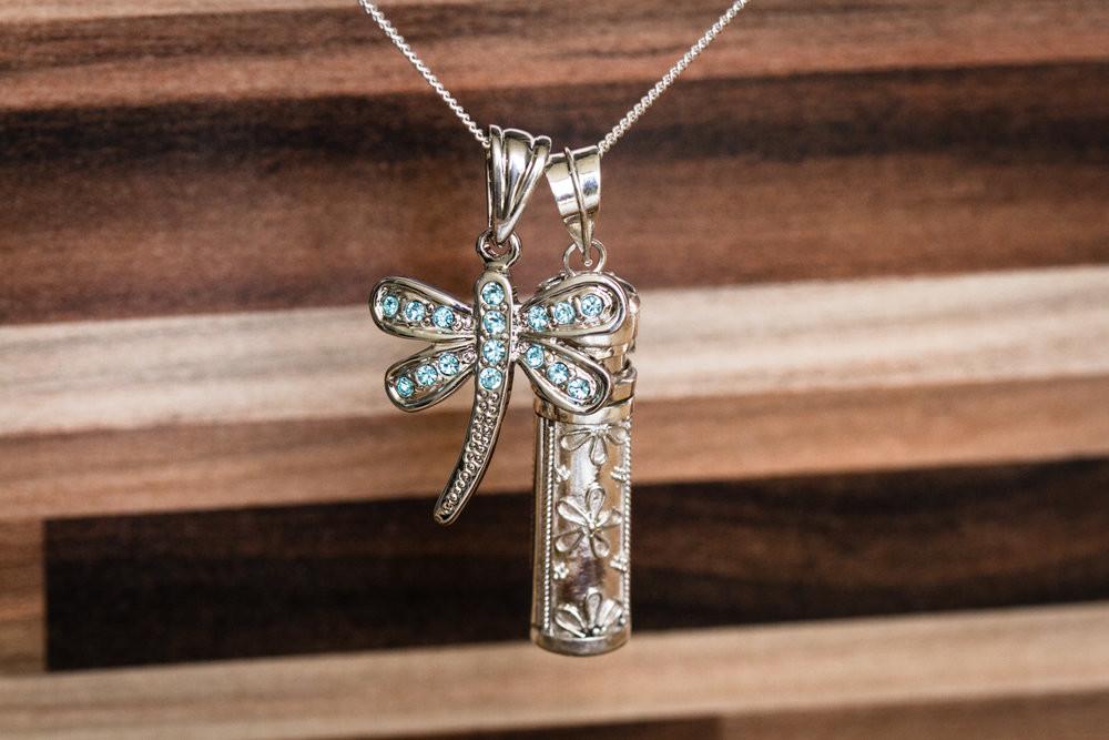 Close-up of the Daisy and Dragonfly Sympathy Necklace showing a crystal dragonfly and a flower patterned cylinder pendant.
