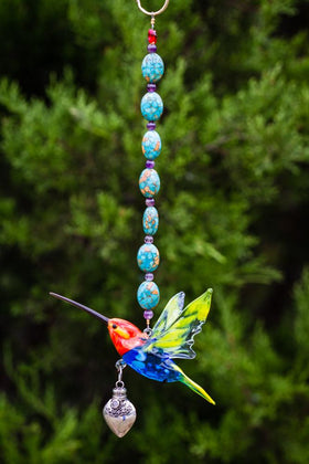Vertical turquoise bead necklace featuring a glass hummingbird and silver heart keepsake pendant.