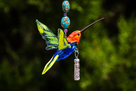 Colorful handmade glass hummingbird pendant with a sterling silver cremation keepsake cylinder and beaded hanger