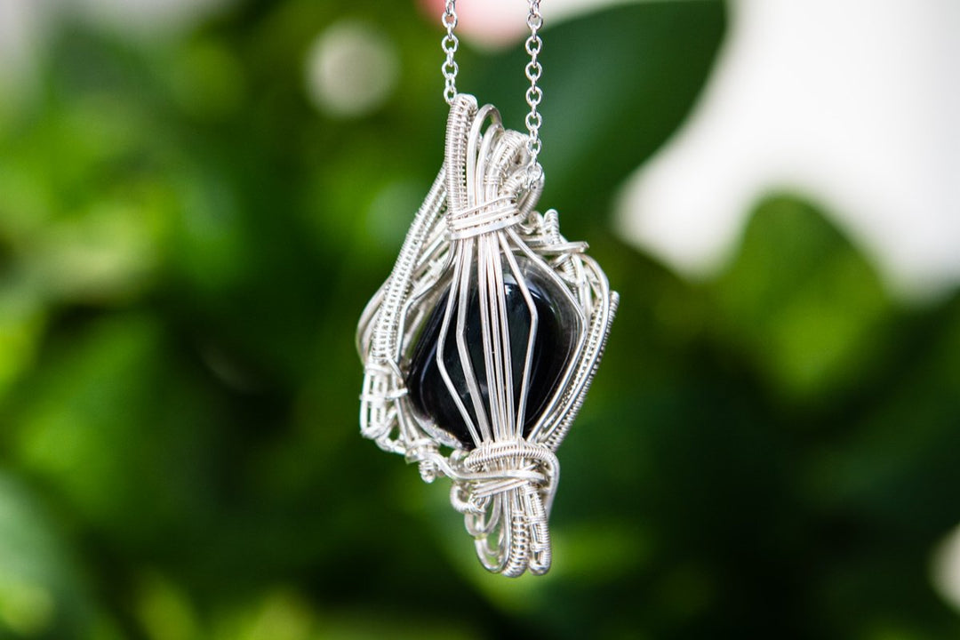 Front view of the Madison pendant showing the infused cabochon with ashes, wrapped in silver wire and hanging on a chain.
