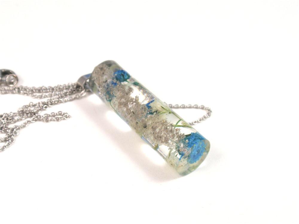 Crystal resin necklace pendant containing white and blue baby's breath embedded on a stainless steel chain