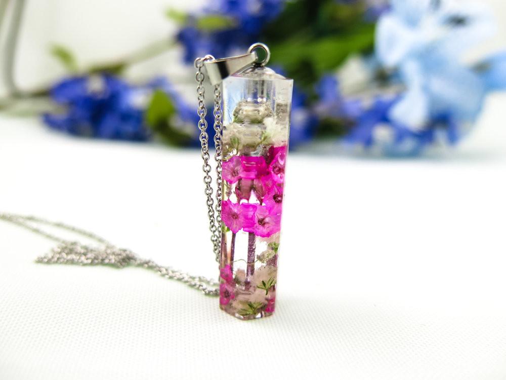 Crystal resin pendant with pink blossoms embedded inside on a stainless steel chain